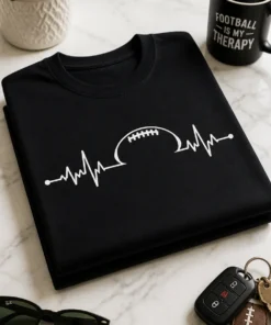 Minimalistisches Herzschlag-Motiv mit Football auf einem schwarzen T-Shirt